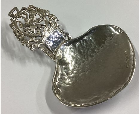 A large textured silver caddy spoon with floral decoration. London 1876. By WK. Approx. 29 grams.