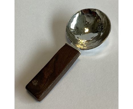 An unusual textured silver caddy spoon with wooden handle. London 2006. By SDJ. Approx. 16 grams.