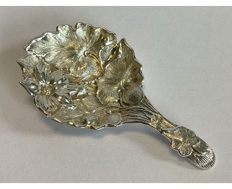 A good chased silver caddy spoon with leaf and floral decoration. Sheffield. By HH. Approx. 11 grams.