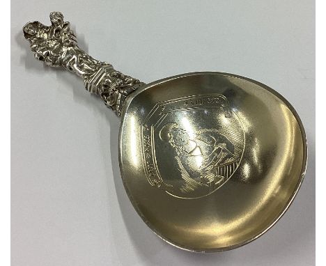 A large Continental silver and silver gilt Apostle top caddy spoon with engraved decoration. Approx. 54 grams.