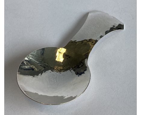 GUILD OF HANDICRAFTS: A heavy silver caddy spoon of shaped form. London 1983. Approx. 22 grams.