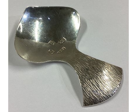 A stylish silver caddy spoon with textured handle. London 1990. By AMN. Approx. 15 grams.