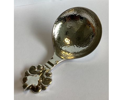 A large silver plated caddy spoon of stylised form with textured bowl. Approx. 71 grams.