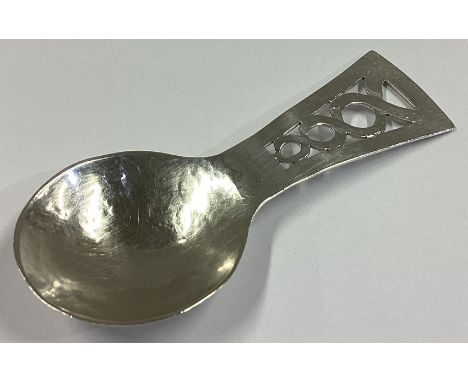 A stylish pierced silver caddy spoon of textured form. London. By CP&J. Approx. 17 grams.