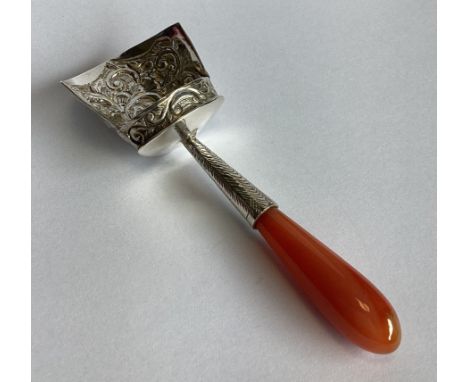 A good chased Georgian silver caddy scoop with turned coral handle. Apparently unmarked. Approx. 19 grams.