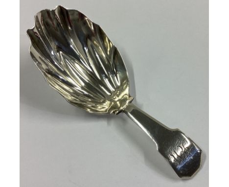 A good fluted silver caddy spoon with fiddle pattern handle. London. By JS. Approx. 11 grams.