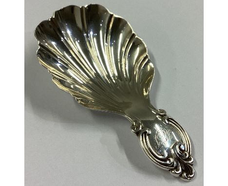 A large heavy Victorian silver caddy spoon with fluted bowl and scroll decoration. Sheffield 1858. By MH&Co. Approx. 19 grams