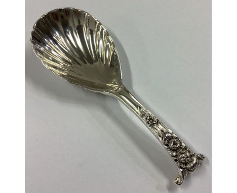 A heavy cast silver caddy spoon with floral decoration. London 1884. Approx. 28 grams.