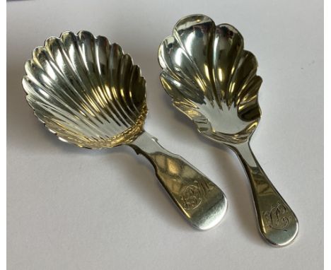 A heavy Georgian silver fiddle pattern caddy spoon with fluted bowl together with another similar example. Various dates and 