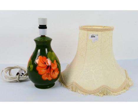 Moorcroft Pottery - A table lamp decorated in the Hibiscus pattern, reserved against a green ground, approximately 28 cm heig