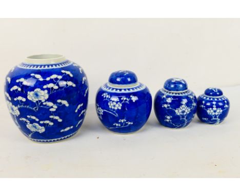 A collection of blue and white ginger jars (three with covers), decorated with prunus, largest with four character Kangxi mar