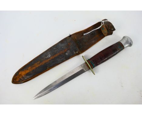 A William Rodgers Fairbairn Sykes style fighting knife, I Cut My Way, 13.8 cm blade, with leather sheath. [W]Note: This lot i