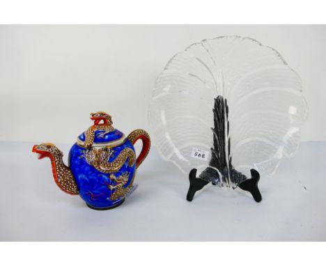 A large clear glass platter in the style of a leaf 31.5 cm x 31.5 cm and a Japanese lidded teapot with snake decoration on a 