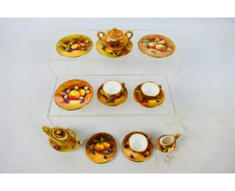 A collection of miniature Coalport tea wares decorated with fruit comprising teapot, sugar bowl, milk jug, four saucers and s