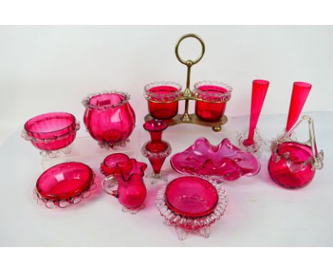 A pair of cranberry glass dishes with clear glass frilled decorated to the upper rims 9.5 cm (h) contained in a metal stand o
