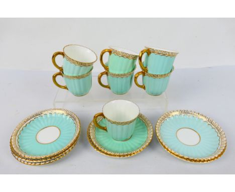 A set of seven Royal Crown derby gilt and pale blue ground, fluted coffee cups and saucers, saucers 12 cm (d), green printed 