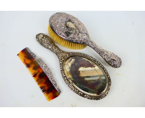 Three late Victorian silver backed dressing table items comprising hand mirror, brush and comb, Birmingham assay 1897. [W]