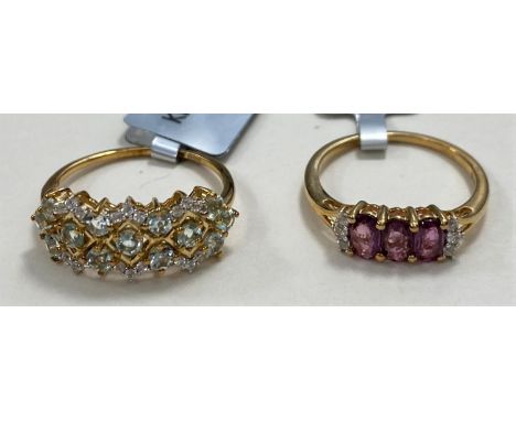 A 9ct gold ring set with 3 oval Thai rubies 0.8cart and white zircons, size L/M, 1.6gms; a 9ct gold dress ring set with Aquai