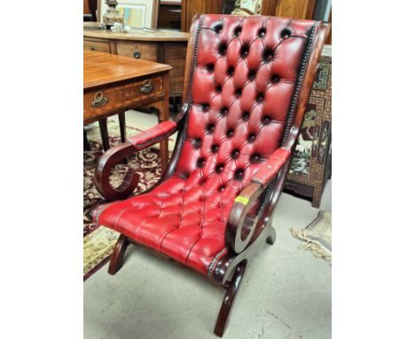 A deep button back arm chair with red leather 