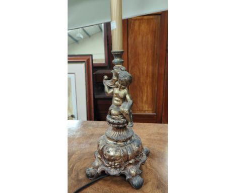 An ornate gilt metal table lamp and shade in the form of a cherub; an urn shaped table lamp and shade 