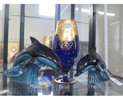 Two Poole dolphins and a blue and gilt glass vase 27cm (2) 