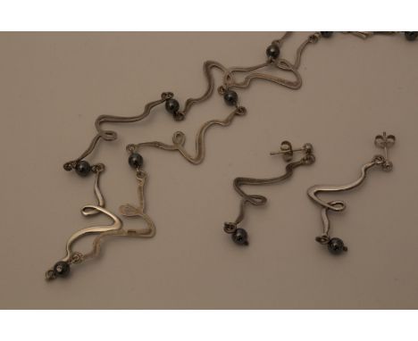 A silver neck chain and matching earrings 