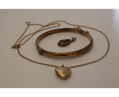 A 9 carat gold bangle with a chain and heart pendant and a garnet pendant,&nbsp;16.9gms in total, bangle 13.47gms (approx)