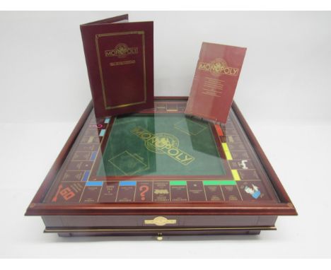 A Franklin Mint Monopoly The Collectors Edition board game, the mahogany board with green baize central section and removable