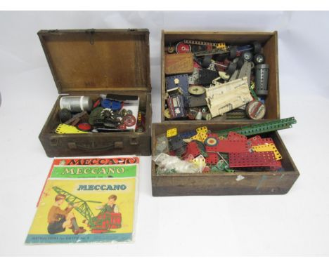 A quantity of loose vintage Meccano components in three wooden boxes, with three Meccano outfit instruction booklets