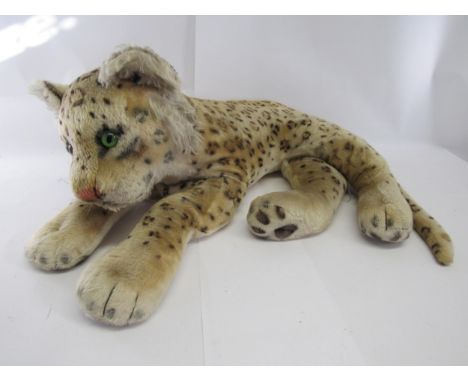 A large mid 20th Century Steiff reclining leopard, with stitched nose and green glass eyes, no button, approx. 68cm length