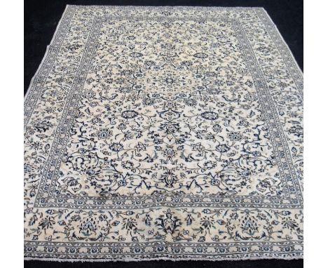 A Kashan hand-knotted ivory-ground wool drawing room rug with multi-coloured floral and foliate decoration with double border