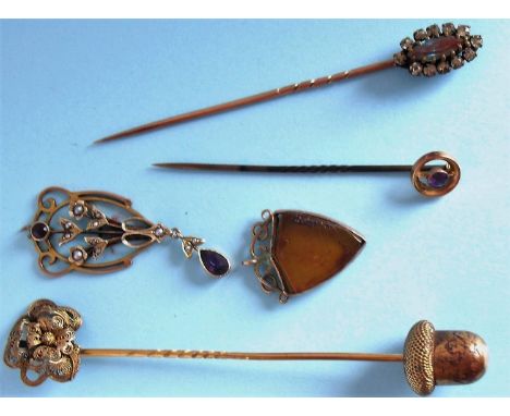 An early 20th century gold-framed filigree pendant with pearl set and amethyst coloured stones,  a gold-framed shield shape b