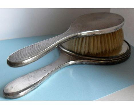 A Garrard & Co. silver engine turned lady's vanity mirror and brush, London 1964 and a lady's silver oval locket and chain wi