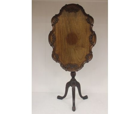 An early 20th Century Chippendale style mahogany tilt top table, carved top