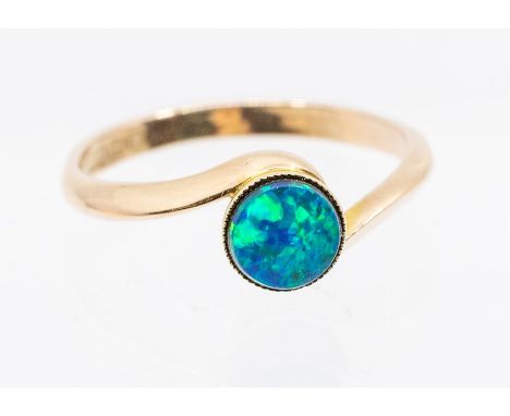 An opal and 9ct rose gold cross over ring, comprising a round opal collet set, blue and green play of colour, cross over tape