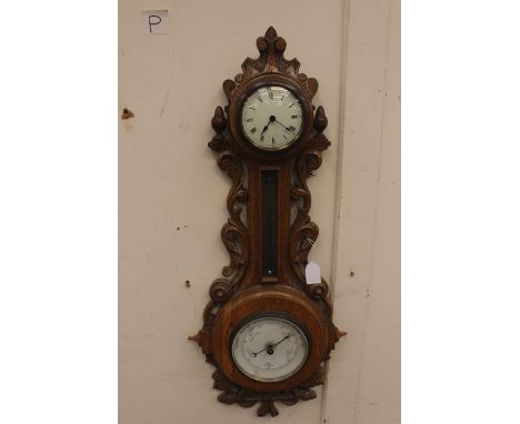 An Edwardian style oak cased wall clock and barometer together with an oak framed wall mirror with lower compartment (2)&nbsp