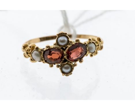 A Victorian garnet and pearl  15ct gold ring, comprising two oval cut garnets within a quatrefoil of half pearls and bead dec