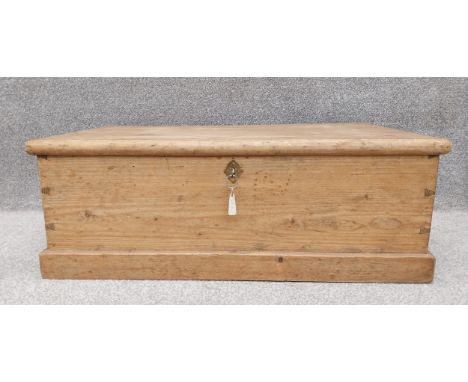A C.1900 pine trunk/chest on a plinth base, with key. H.34 W.92 D.52cm