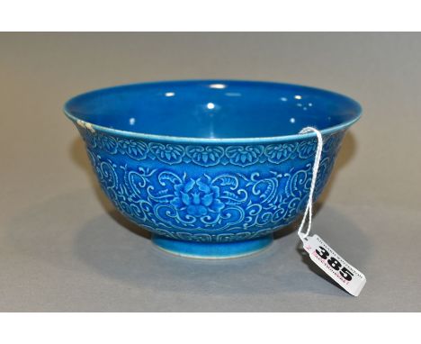 A CHINESE PORCELAIN BLUE GROUND BOWL, moulded in relief to the exterior with flowers, scrolls and other motifs, impressed sea