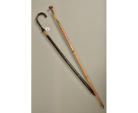 TWO ANTIQUES SWORD STICKS, the one has a carved bone handle and its oblong shaped blade is marked Toledo, the brass ferule wh