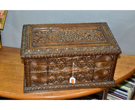 A 19TH CENTURY HEAVILY CARVED OAK TEA CADDY, hinged lid opening to reveal two fixed rectangular caddies, one with broken hing