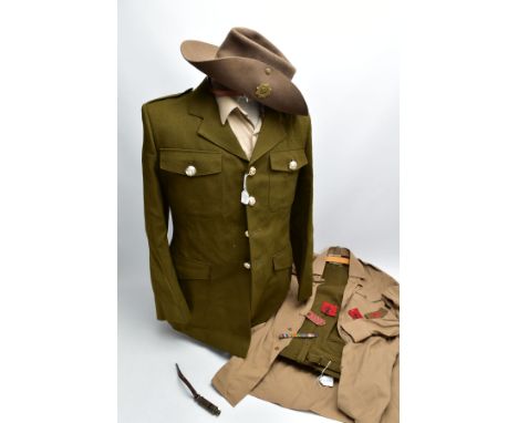 A MODERN BRITISH ARMY UNIFORM JACKET, TROUSERS AND TWO SHIRTS on hangers with suit protection bag, the jacket is named to a S