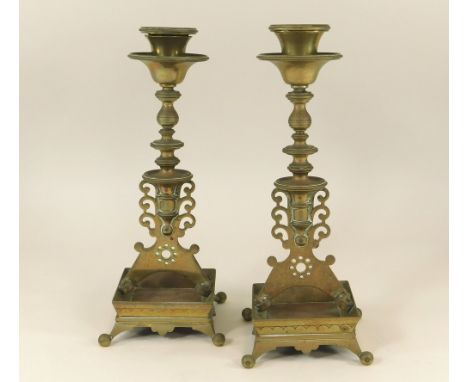 CANDLESTICKS. A pair of High Victorian brass candlesticks with integral drip tray. Height 26cm.