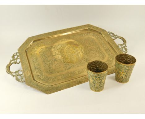 INDIAN BRASS WARE.An Indian brass tray, decorated with figures, 36 x 63cm & a pair of brass beakers, similarly decorated.