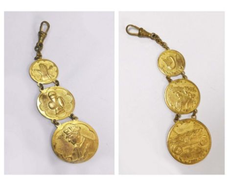 MOTORING FOB.An early 20th century gilt metal watch chain fob, featuring a motorist, a car lamp, driving lamp & tools etc.