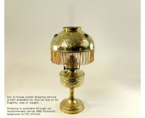 OIL LAMP.An Art Nouveau brass oil lamp, the brass fount moulded with water lilies, the jewelled shade similarly moulded. Heig