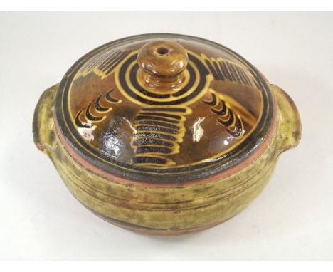 MICHAEL CARDEW. A Michael Cardew, Winchcombe slipware casserole &amp; cover. Impressed personal mark. Diameter 25cm.