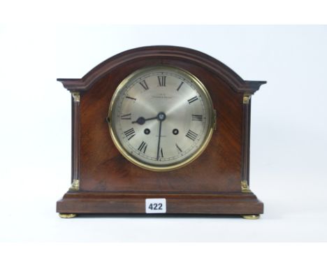AN EARLY 20TH CENTURY MAHOGANY ARCHED TOP MANTLE CLOCK, silvered dial with French movement retailed by Hamilton &amp; Inches,