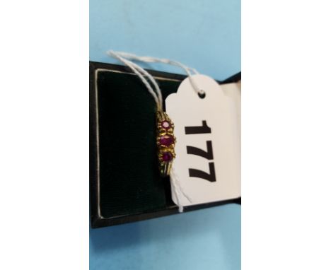 A LADY'S 18CT YELLOW GOLD THREE STONE RUBY RING with carved shoulders, stamped 750, size R, approximately 3.8 grams.   