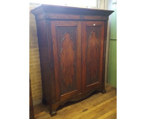 A 19TH CENTURY GEORGIAN REVIVAL MAHOGANY WARDROBE, the moulded cornice above a pair of blind fret carved and panelled doors, 